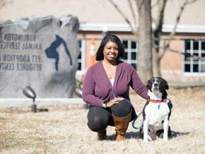 Amber Currie kneels outside of the an animal shelter with her dog